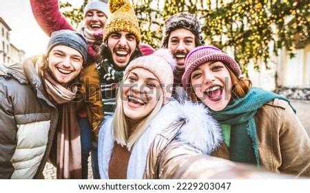 Happy friends group wearing winter clothes taking selfie walking on city street - Cheerful young people hanging outside enjoying winter holidays - Friendship concept with guys and girls laughing loud