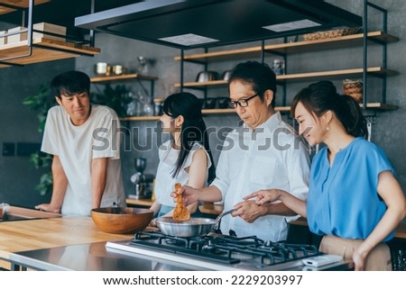 Asian man cooking food for home party in kitchen Royalty-Free Stock Photo #2229203997