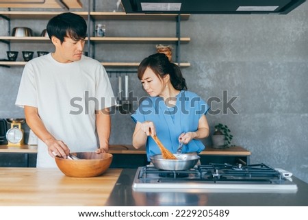 Asian man and woman fighting while cooking Royalty-Free Stock Photo #2229205489