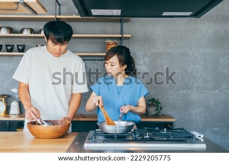 Asian man and woman fighting while cooking Royalty-Free Stock Photo #2229205775