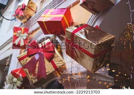 New Year Christmas street decorations of cafe or store facade entrance front shopwindow showcase, shopfront decorated with colorful red and golden gift present boxes with ribbons, boutique outside
