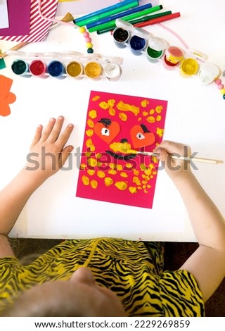 Child making homemade greeting card from paper. Gift for Mothers day, Fathers day, Birthday or Valentines day.  Kid craft. Home Education game. development concept