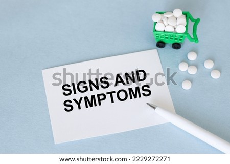 SIGNS AND SYMPTOMS text on a card on a blue background next to the pen and white tablets