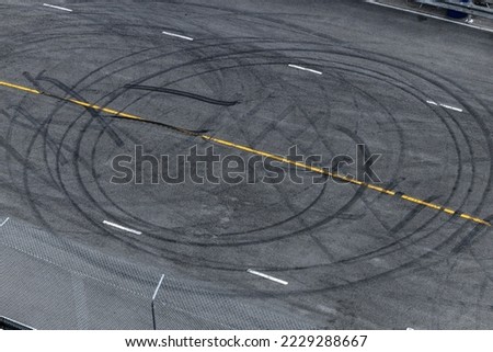 Tire tracks texture and background, Asphalt texture with line and tire marks, Automobile automotive tire skid mark on race track, Abstract texture car drift tire skid mark. Royalty-Free Stock Photo #2229288667