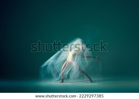 Emotions in dance. Graceful ballet dancer dancing with white cloth, fabric isolated on green background. Concept of art, motion, action, flexibility and inspiration concept. Blurring effect Royalty-Free Stock Photo #2229297385