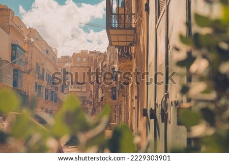 Picturesque streets and alleys of Valletta, Malta on summer sun. Visible long facades and balconies on them.