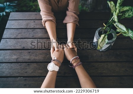 Cropped women holding hands each other during date time for communicate and talking, unrecognizable female praying togetherness during spiritual assistance and ritual patience for support Royalty-Free Stock Photo #2229306719