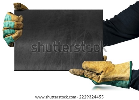 Manual worker with protective work gloves holding a blank chalkboard with copy space, isolated on white background with reflections,