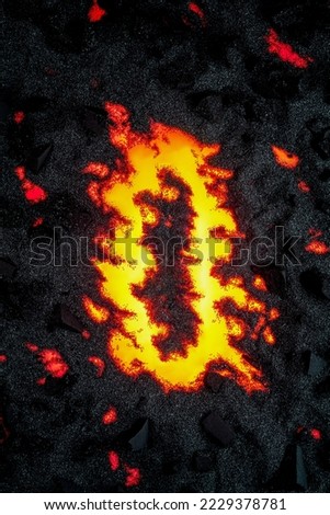 Decorative lava background with charcoal and black sand glowing red bright fire from below