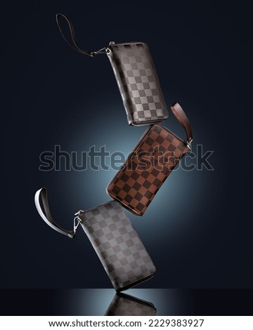 Men's leather wallets clutches on black background with reflection Advertising concept photo  Royalty-Free Stock Photo #2229383927