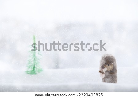 Cute little hedgehog on snowy winter background, blur forest, snowflakes, snow, bokeh. Hedgehog in fog. New Year or Christmas holidays background