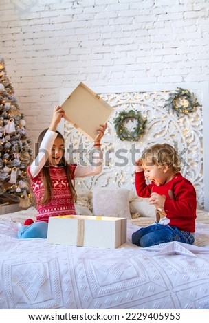 Children open Christmas gifts under the tree. Selective focus. Kid.