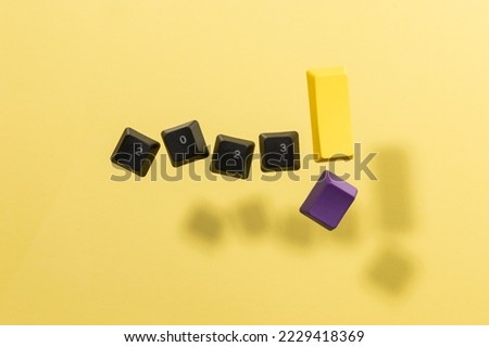 Keyboard keys spelling 2023! on yellow background