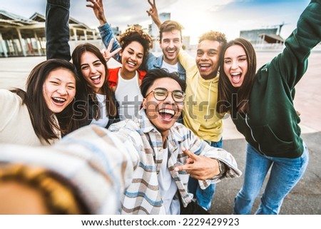 Multicultural happy friends having fun taking selfie group photo portrait outside - University students smiling together at camera in college campus - Teenagers hanging out on city street