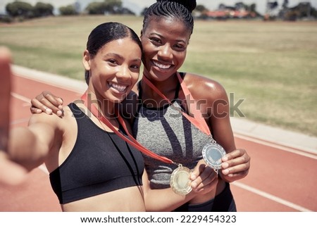 Fitness, selfie and runner girls with medal celebrate winning success at running event at stadium. Sports, friends and support, happy winner women with smile taking picture together on track in sun.