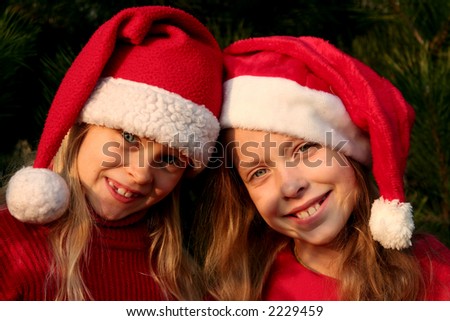 Portrait of two girls wearing Santa Claus hats