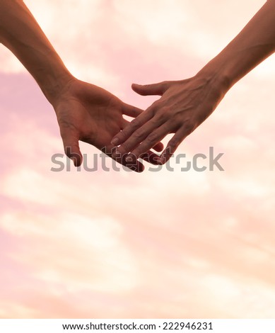 Couple holding hands and watching a beautiful sunset