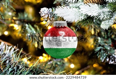 New Year's glass ball with the flag of Hungary against a colorful Christmas background
