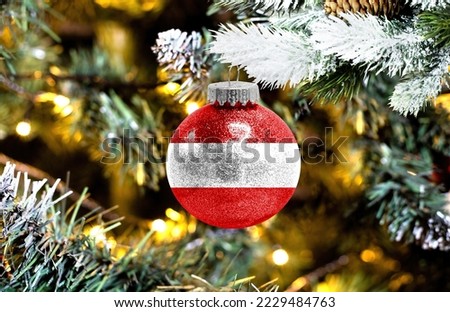 New Year's glass ball with the flag of Austria against a colorful Christmas background