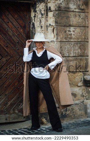 A stylish girl walks through the old streets of Lviv