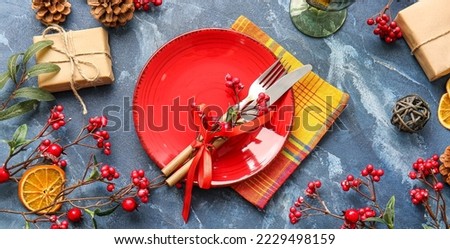 Beautiful Christmas table setting with mistletoe on blue background