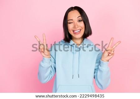 Photo portrait of lovely young girl show double v-sign wink tongue out cheerful wear trendy blue clothes isolated on pink color background