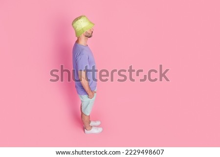 Full size photo high angle profile view of handsome young guy look empty space dressed trendy blue look isolated on pink color background