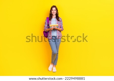 Full body size photo of young satisfied woman hold stack books backpack preparation next exam science isolated on yellow color background