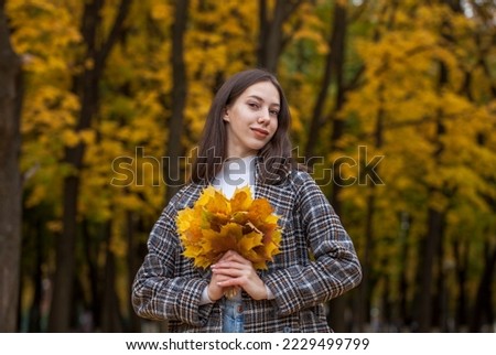 Portrait of a young beautiful brown-haired girl with freckles on her face, autumn outdoor