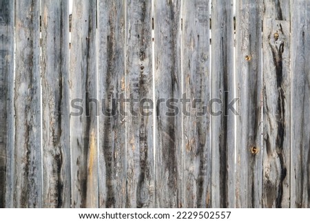 A gray wooden fence with tightly nailed vertical slats. Background structure.