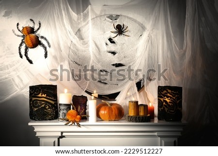 Different Halloween decor on fireplace indoors. Festive interior