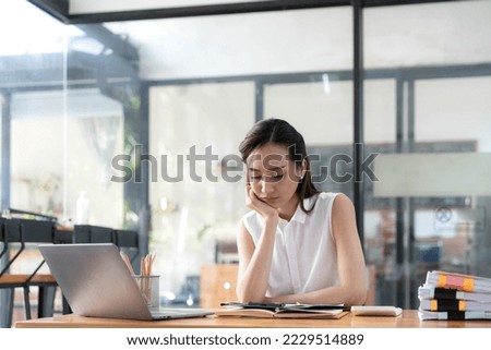 Young Business Asian women are stressed while working on laptop, Tired asian businesswoman with headache at office, feeling sick at work copy space in workplace an home office. Royalty-Free Stock Photo #2229514889