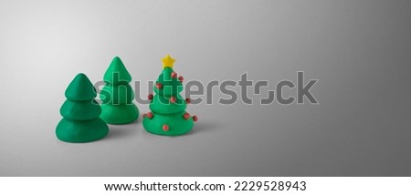 Set of elegant shapes of christmas pine trees made of green plasticine with copy space. Design concept of pine trees on a gray gradient background, for greeting or invitation card