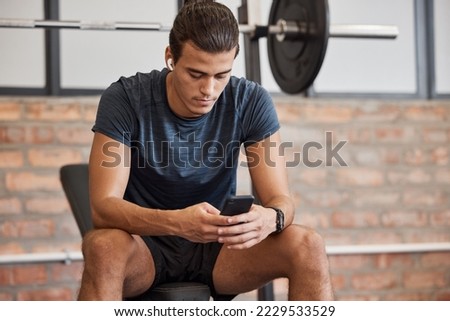 Fitness, relax and phone with man in gym for training, workout or exercise. Social media, internet and music with bodybuilder athlete and mobile for health, wellness or performance in sport club