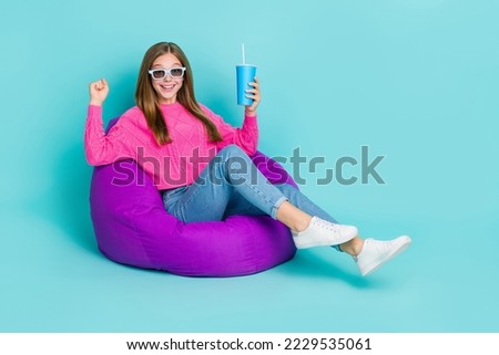 Full length photo of overjoyed lady sit comfort chair rejoice weekend holiday empty space isolated on cyan color background