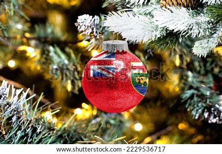 New Year's glass ball with the flag of Manitoba against a colorful Christmas background