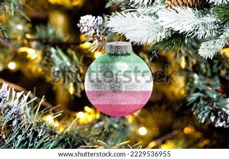 New Year's glass ball with the flag of Abrosexuality against a colorful Christmas background