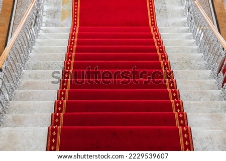 Red carpet is at a white stone stairway, top view, background photo