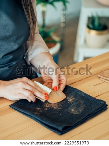 Close Up Photo Of Woman Hands Polishing With Sand Paper A Heart Made Of Clay At Her Studio