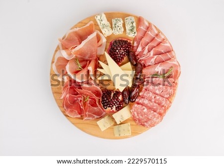 Mixed delicatessen with charcuterie and cheese board with a place for text. Italian appetizers or antipasto set with gourmet food on wooden cutting board isolated on white background. Top view Royalty-Free Stock Photo #2229570115