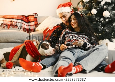 Cute couple sitting at home near christmas tree