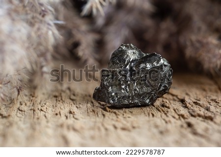 Natural Black Hard Coal Rock Sample on Wooden Background. Brittle Anthracite Shale for Power Production Royalty-Free Stock Photo #2229578787
