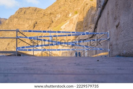 Closed road to the place of crime scene cordoned off with a special police tape in Tenerife, Spain. Local police written on tape