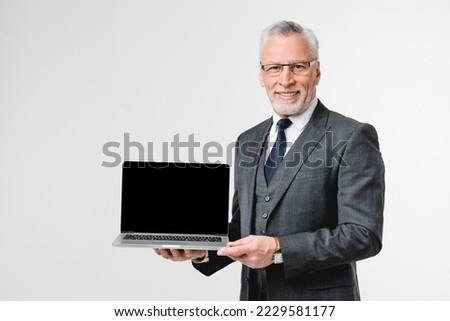 Happy confident caucasian middle-aged businessman ceo boss lawyer showing laptop screen with mockup copyspace for mobile online application isolated in white