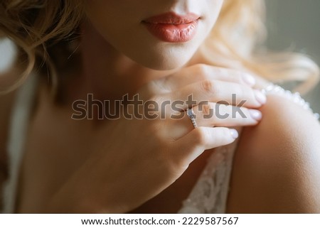 the bride gently touches her dear engagement ring Royalty-Free Stock Photo #2229587567