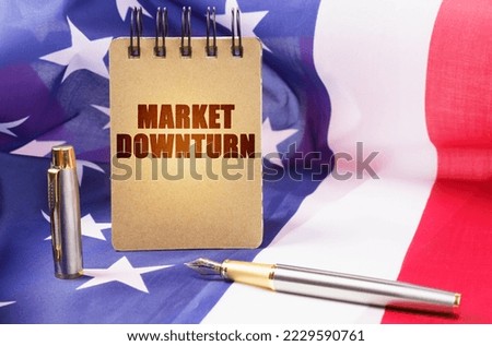 Business concept. Against the background of the American flag is a notepad with the inscription - Market downturn