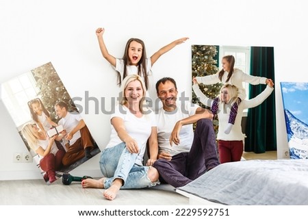 Smiling family holding photo canvas