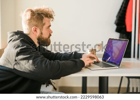 Close-up male guy portrait resting in coffee shop chatting in social networks skilled freelancer enjoying remote job typing publication for web blog on laptop