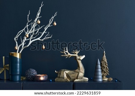 Stylish Christmas living room interior design. Beautiful decoration. Christmas tree, gift box, reindeer and elegant accessories in gold. Merry Christmas and Happy Holidays.