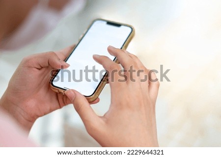 Females hand using smartphone cellphone for calls, social media, mobile web surfing, or shopping online.